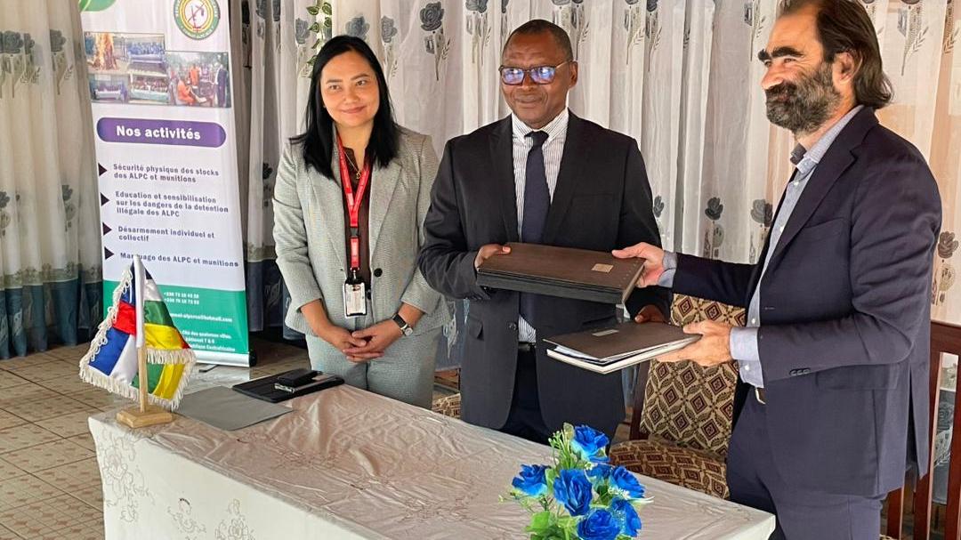 A woman is standing beside two men