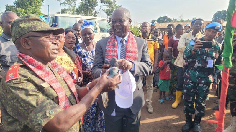 Deux hommes discutent en tenant des oiseaux.